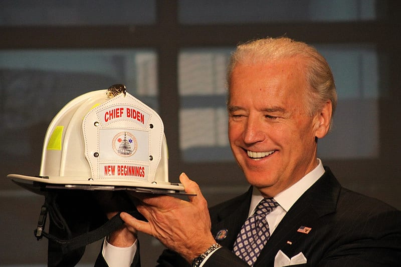 Joe Biden holding a Chief Biden fire helmet