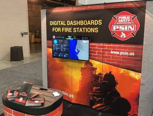 The Public Safety Information Network booth showing digital dashboards for fire stations