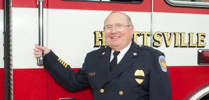 Chief Doc Moltrup in dress uniform beside a Hyattsville engine