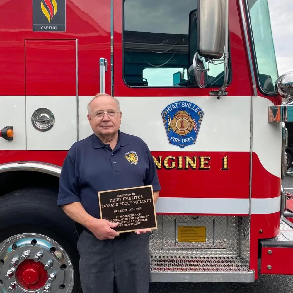 Chief Emeritus Donald "Doc" Moltrup with his dedication plaque by Engine 1
