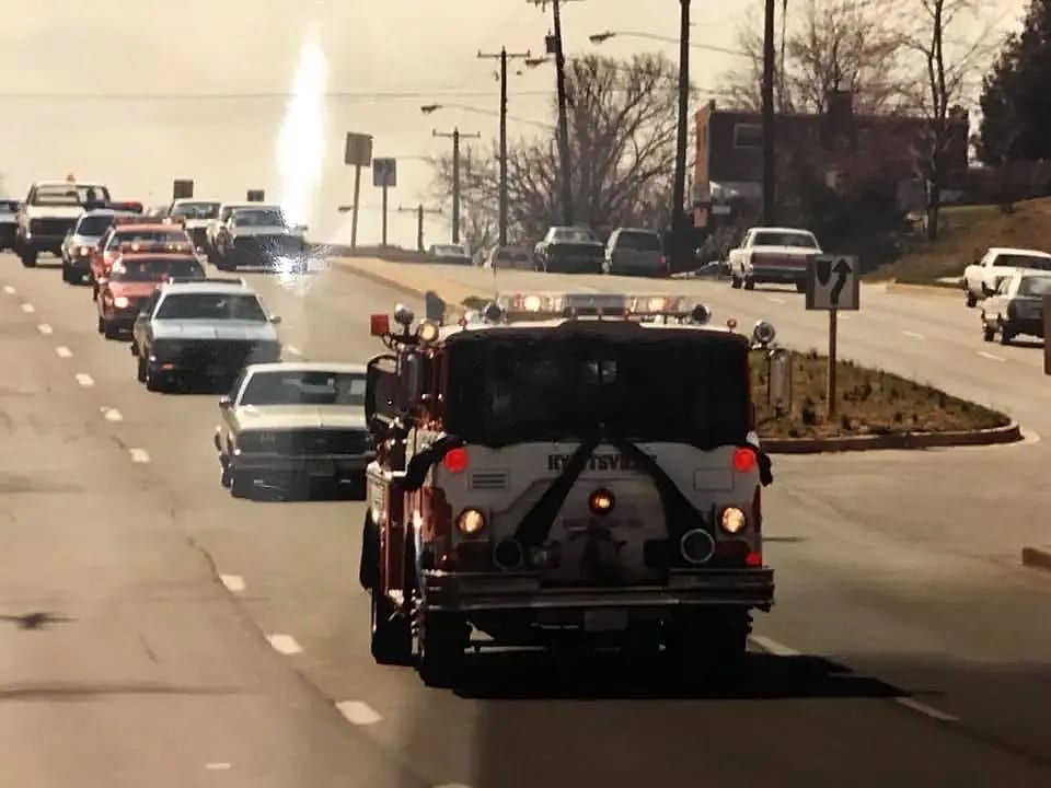 A Hyattsville engine draped in mourning bunting leads a funeral procession